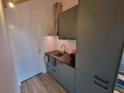 佐特兰德Zoetenaar Zoutelande的厨房配有不锈钢冰箱和水槽