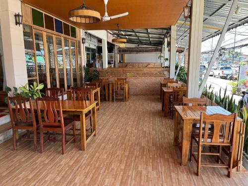 蔻立Srichada Hotel Khaolak - SHA Extra Plus的一间空餐厅,配有木桌和椅子