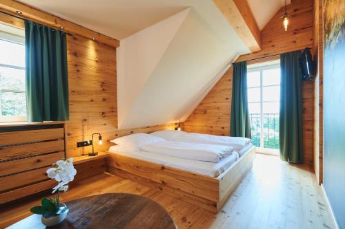 Barweiler阿格内深霍夫酒店的木墙和窗户的客房内的一张床位