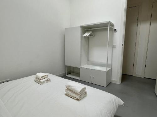 鹿特丹Stylish 2 Bedroom Serviced Apartment in Rotterdam的白色客房,配有带毛巾的床