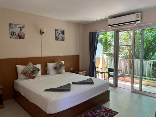 蔻立Srichada Hotel Khaolak - SHA Extra Plus的一间带大床的卧室和一个阳台
