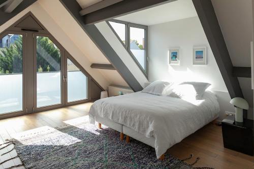 克雷泰伊Maison d'architecte - Piscine的卧室设有白色的床和大窗户