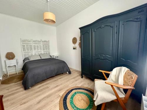 雅莱地区圣梅达尔« La Souillarde »的一间卧室配有一张床和一个蓝色的橱柜