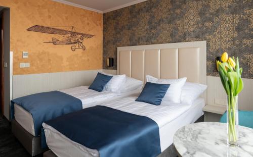 韦切什布达佩斯机场酒店的配有桌子的酒店客房内的两张床