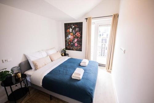 鹿特丹Grandly 3 Bedroom Serviced Apartment 83m2 -NB306G-的一间卧室配有一张大床和两条毛巾