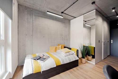 克拉科夫SHED Living Kraków的一间卧室配有一张带黄白色床单的大床
