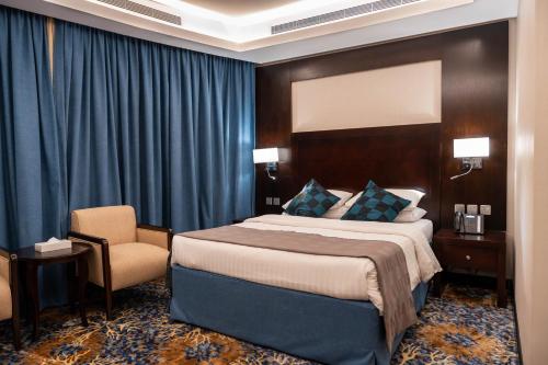 吉达Mercure Jeddah Al Hamraa Hotel的配有一张床和一把椅子的酒店客房