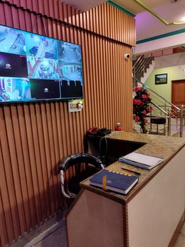 斯利那加Hotel Foothills , Srinagar的客房设有一张桌子,墙上配有电视