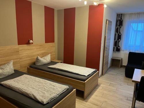 博尔兴Haus Roseneck-Pension Am Stadtrand的红色和黄色带的客房内的两张床