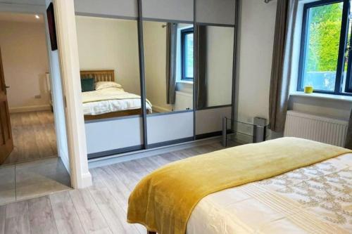 弗萨Aghadoe Millers - Modern 3 bed house Killarney的一间卧室配有一张床和一面大镜子