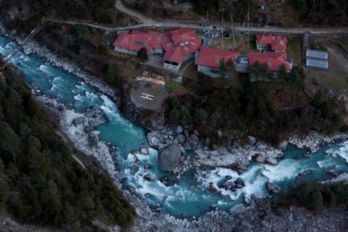 PhakdingMountain Lodges of Nepal - Phakding的享有河边房屋的空中景致