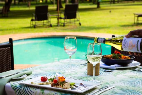 赫卢赫卢韦法拉扎游戏乐园Spa酒店的一张桌子,上面放着一瓶葡萄酒和一盘食物