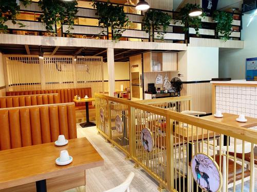 广州Serveyou Apartment - Airport Transfer Service的一间带木桌和椅子的餐厅和一间自助餐厅