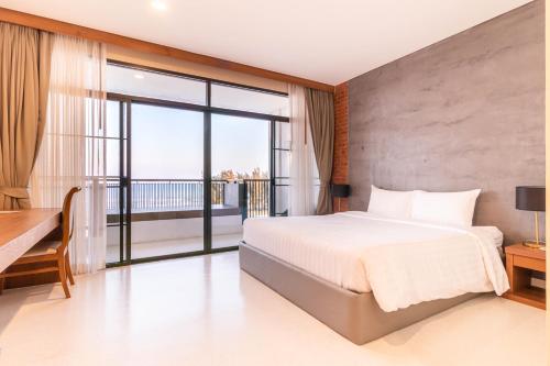 佛丕Sea Sand Sun Hua Hin Resort的一间带大床的卧室和一个阳台