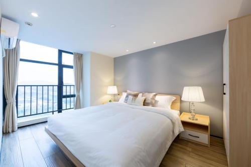 广州Serveyou Apartment - Airport Transfer Service的白色的卧室设有一张大床和一个窗户