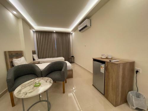 亚喀巴Aster Hotel Aqaba的酒店客房带一张床、一张桌子和椅子