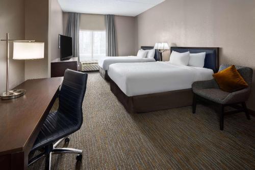 穆尔斯维尔La Quinta Inn & Suites by Wyndham Mooresville的酒店客房配有两张床和一张书桌