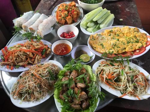 Phú ThọHomestay Long Coc的一张桌子上放着许多盘子的食物