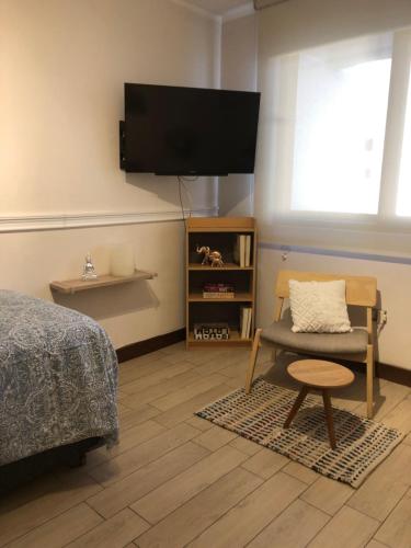 圣地亚哥Departamento Fray León的卧室配有床、椅子和平板电视。