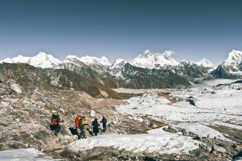 NamcheMountain Lodges of Nepal - Namche的一群人在一个白雪 ⁇ 的山里行走