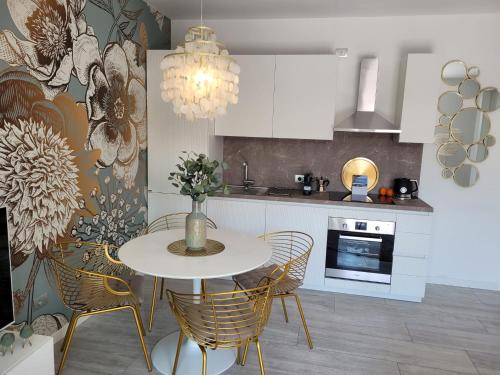 多马索Lago-apartment Midy, sfeervol, zwembad, airco的厨房配有白色的桌子、椅子和炉灶。