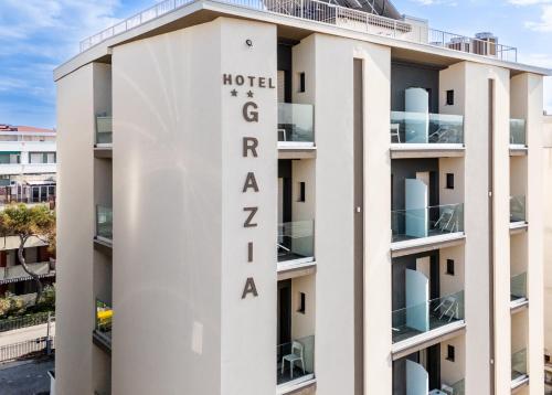 里乔内Hotel Grazia Riccione的一座白色的建筑,设有酒店Zaporaleshmi赌场