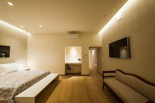 维罗纳Atto Primo Studio Apartment的一间卧室配有一张床、一张沙发和一张书桌