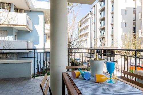 里乔内Appartamenti Desi Riccione的阳台上配有桌椅和玻璃杯