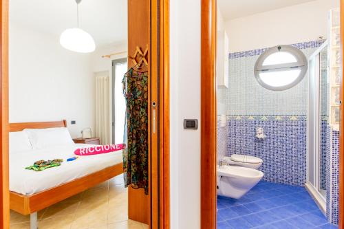 里乔内Appartamenti Desi Riccione的一间卧室配有一张床,浴室设有卫生间
