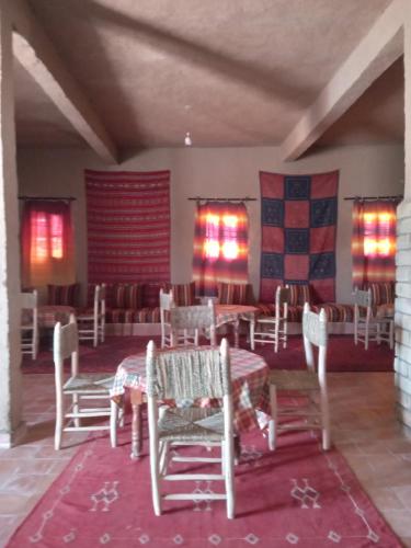 梅尔祖卡Hostel la palmeraie merzouga的一间用餐室,在房间内配有桌椅