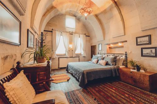 乌奇希萨尔Kale Konak Cappadocia的一间卧室配有一张床和一个沙发