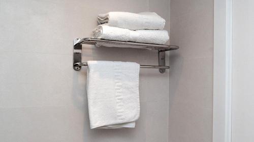 巴塞罗那Hotel Coronado的浴室毛巾架上的一组毛巾