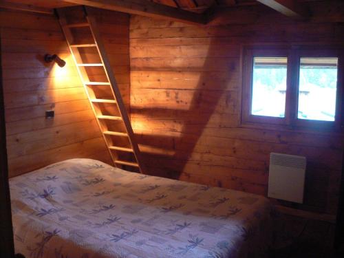 大博尔南Chalet Aravis的卧室设有木墙梯子