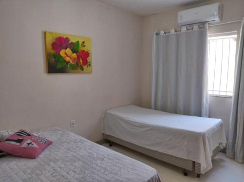 古里里Casa de Praia Lado Sul的一间卧室设有两张床,墙上挂着一幅画