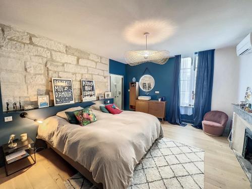 阿维尼翁Appartement de charme avec cour的一间卧室设有一张大床和石墙