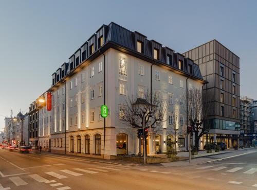 萨尔茨堡Hotel Zum Hirschen Salzburg的街道拐角处的大建筑