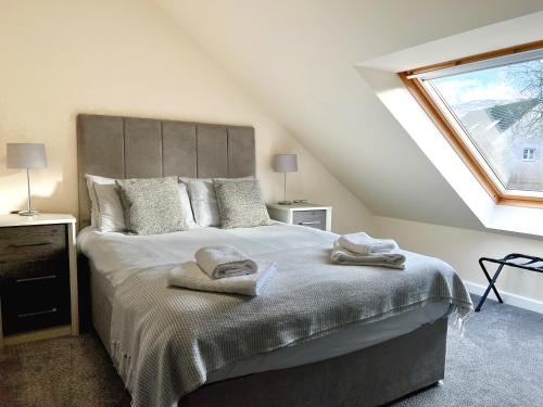 奥古斯都堡Loch Ness Gate House的一间卧室配有一张床,上面有两条毛巾