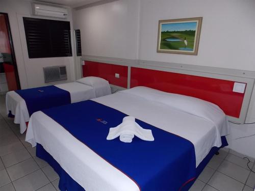 普鲁登特总统城罗塔多潘塔纳尔酒店的酒店客房,配有两张床,并备有毛巾