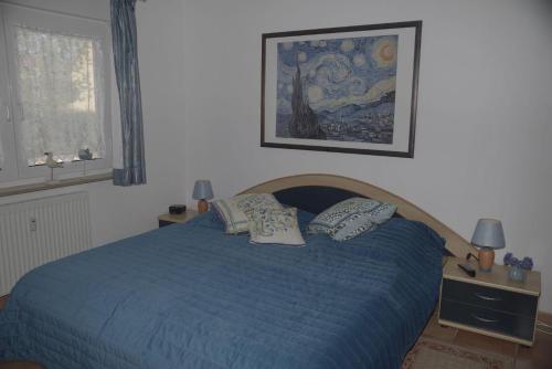 奥斯赛拜-屈隆斯博恩Ferienanlage-Reriker-Strasse-EG-links-9388的一间卧室配有蓝色的床和两个枕头