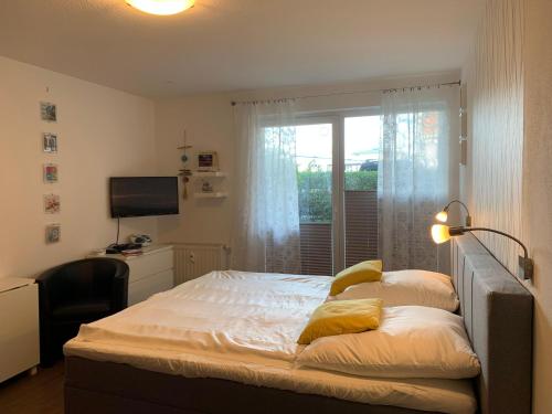 奥斯赛拜-屈隆斯博恩Yachthafenresidenz-Wohnung-8106-9412的一间卧室配有一张带窗户的床和一张书桌