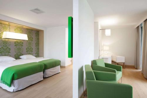 阿姆斯特丹阿姆斯特丹北NH酒店的一间卧室配有绿色的床和绿色椅子