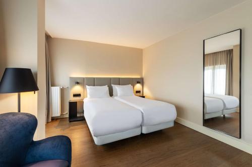 阿姆斯特丹阿姆斯特丹席勒NH酒店的卧室配有一张白色大床和镜子