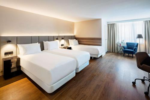 阿姆斯特丹阿姆斯特丹席勒NH酒店的酒店客房,配有两张床和椅子