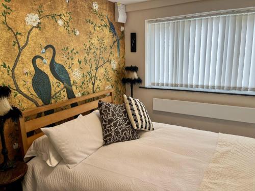 淡水Lovely independent 1-Bed Apartment in Freshwater的一间卧室配有床和鸟墙