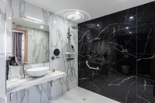 罗尼苏布瓦Brit Hotel Privilège Paris Rosny-sous-Bois的浴室设有黑色和白色的大理石墙