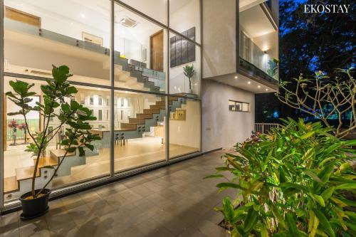 卡兰古特EKOSTAY Luxe I Avante Villa的建筑里一个有植物和楼梯的空走廊