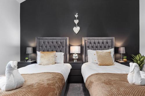 布莱克浦Luxury by the Sea, Beautiful 3 bedroom House with Fast WiFi, King Bed, Lovely Garden! Blackpool's Finest Getaway Experience for up to 8 Guests!的卧室内两张并排的床