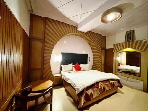 西姆拉Ganga Hotel Near Mall Road的一间卧室配有一张床和一把椅子