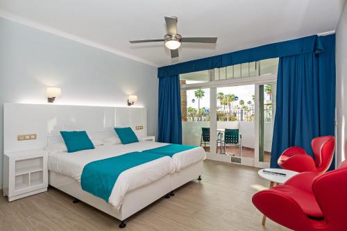 卡门港全景公寓酒店 - 仅限成人入住的一间卧室配有一张床和一张红色椅子