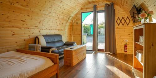 弗罗德舍姆Original Glamping Pod with Hot Tub的一间卧室,卧室内配有一张床和一把椅子